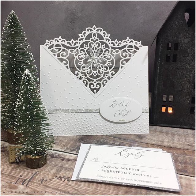 Christmas Wedding Invitations. Finding the perfect balance between  Wedding elegance with a Christmas theme… These invitations were hand die cut. Crisp white card, hand embossed falling snow added to the front, finished with silver ribbon, a delicate silver glitter snowflake, and a single pearl